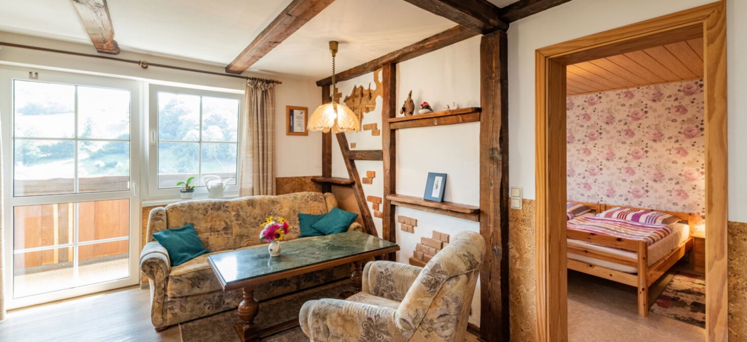 Innenaufnahme Zimmer mit Sofa, Sessel, Fachwerk, Balkon