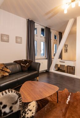 Innenaufnahme Zimmer mit Fachwerkbalken, Sofa und Doppelbett