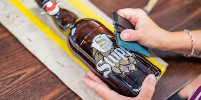 Stupps Brauerei Steinbach Beklebung einer Flasche mit dem Etikett der Stupps Brauerei in Steinbach