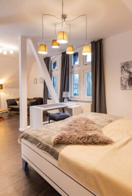 Innenaufnahme Zimmer mit Fachwerkbalken, Doppelbett und Sofa