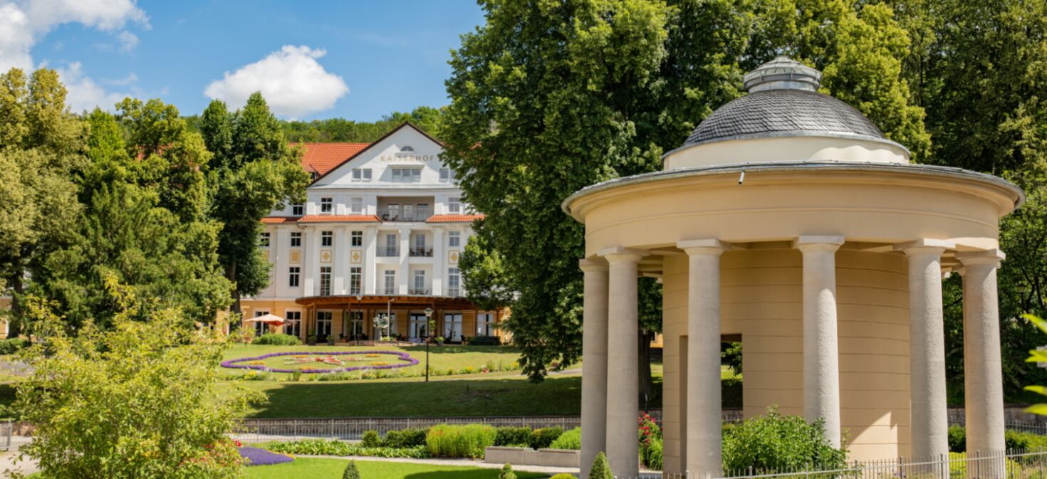 Landschaftsaufnahme mit Brunnentempel, historischem Kurpark und Kulturhotel Kaiserhof im Hintergrund